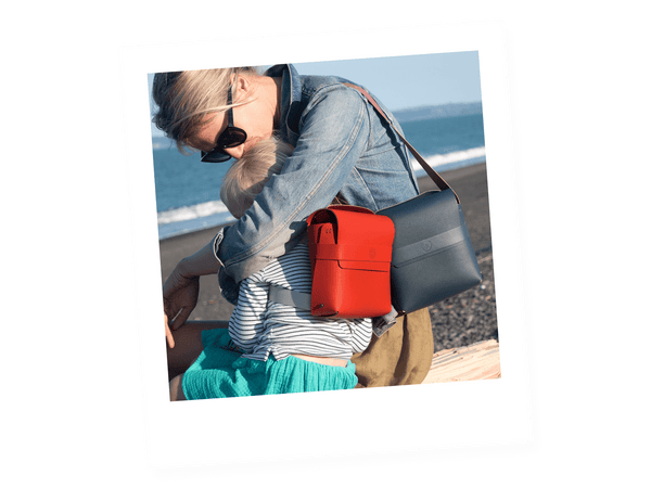 mother and daughter with blue shoulder bag and red backpack